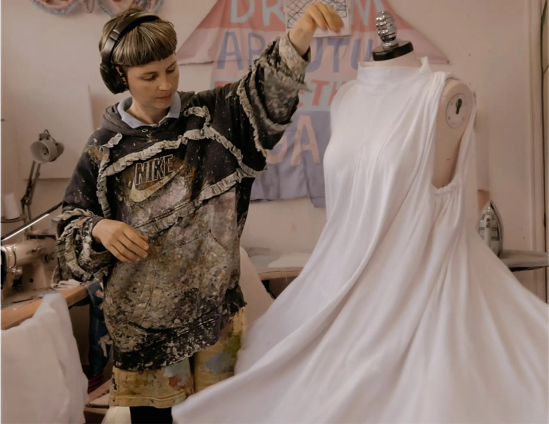 Still from the film: Janelle Abbott draping fabric on a dress form in her studio